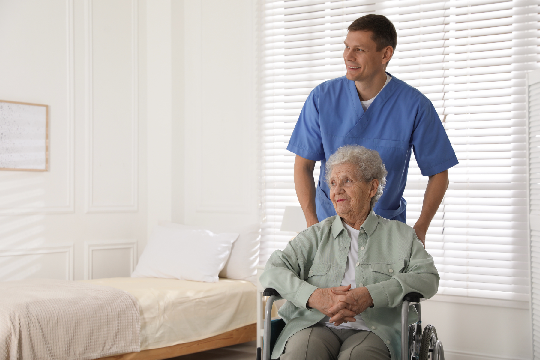 male-nurse-pushing-wheelchair-patient_493837639